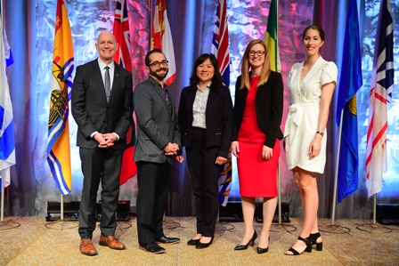 Craig Johnson on left, with other winners of Robert Wood Johnson Award, flags in background