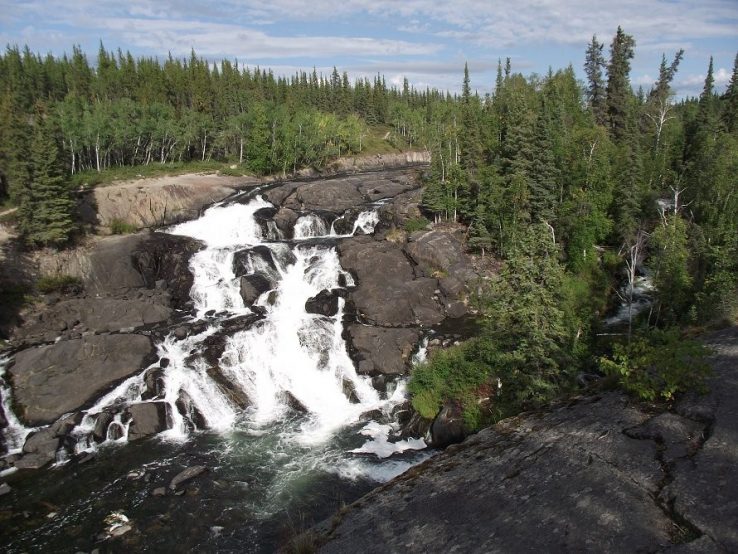 Cameron Falls, cascades down rock formation with coniferous fir trees surrounding it