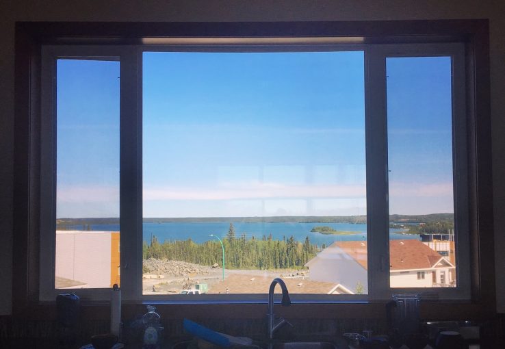 View of Great Slave Lake, surrounded by trees, as seen through kitchen window of blog author