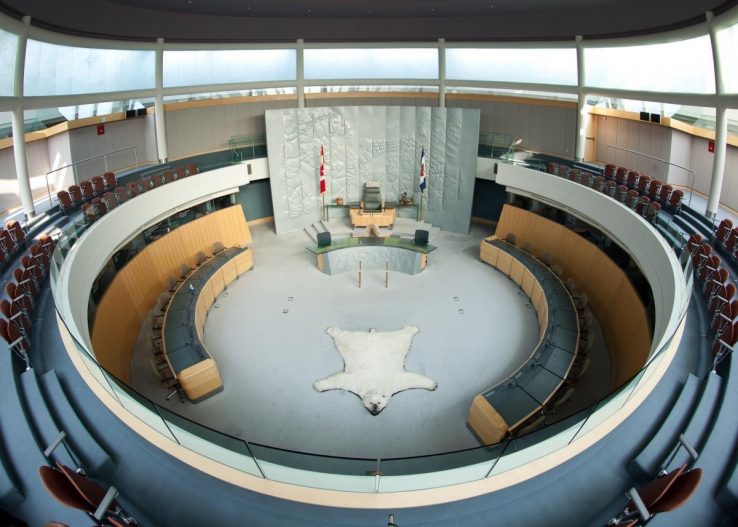 Circular architecture with two levels of chairs, a polar bear rug lies in the centre of the chamber