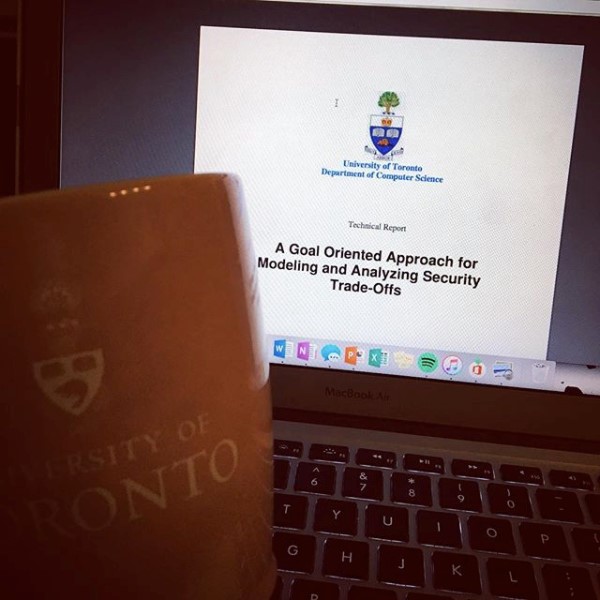 Foreground image of UofT mug, in background image of laptop screen