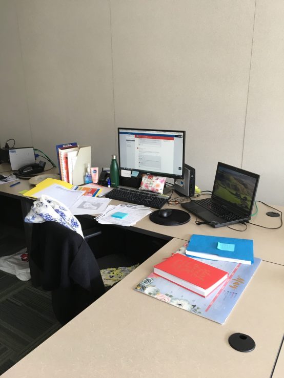 Desk with papers in disarray and laptop open