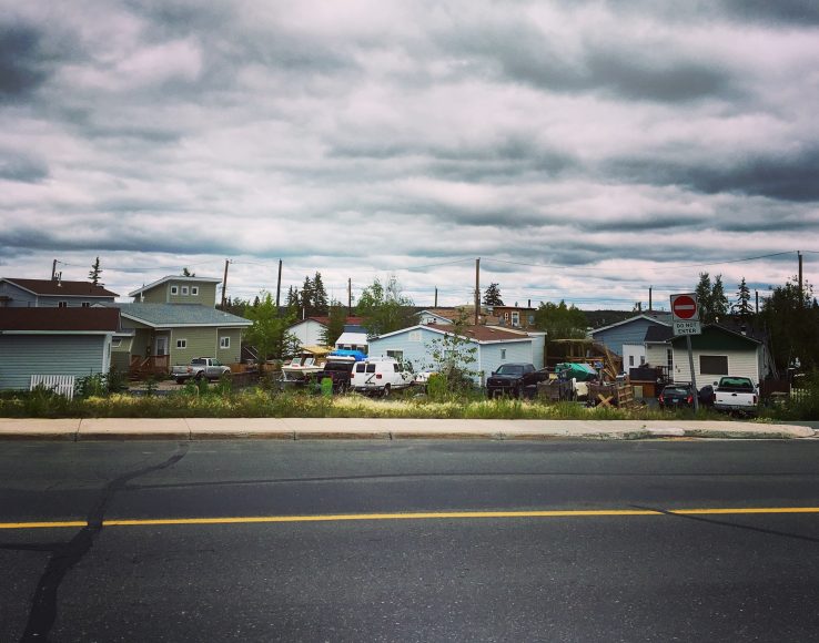 Street in Yellowknife with houses and smoky grey and cloudy sky above