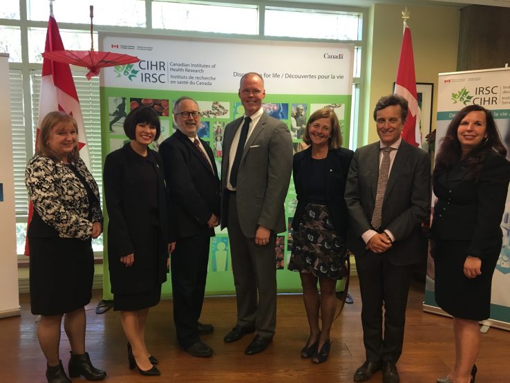 Group of collaborators with Minister of Health Ginette Petitpas Taylor, surrounded by Canadian Flags