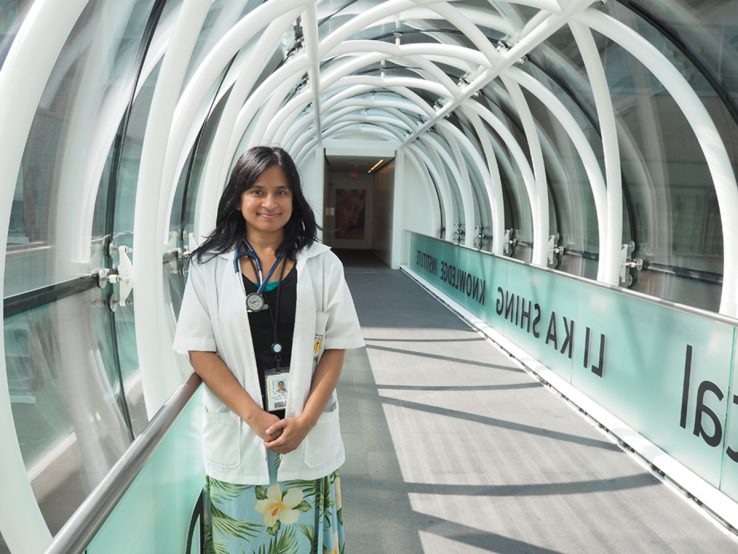Profile of Sharmistha Mistra in lab coat under archway, bridge at La Ka Shing Knowledge Institute