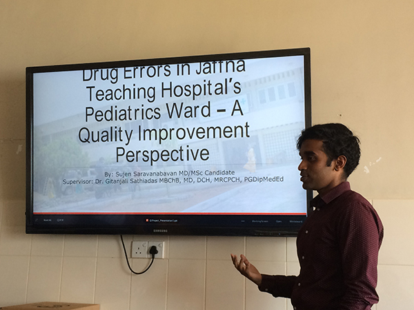 Sujen Saravanabavan running a quality improvement course at Jaffna Teaching hospital, screen in background with Sugen on right side of image