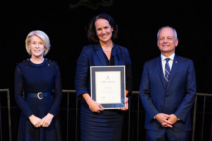 Rose Patten U of T Chancellor, Lee Fairclough, and U of T President Meric Gertler at the U of T Arbor Awards holding award with black drape behind