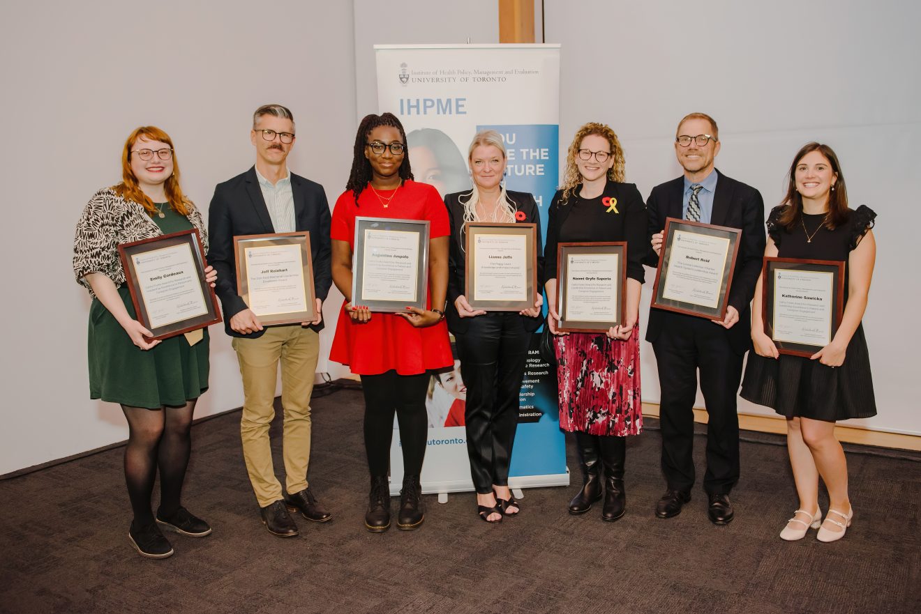 Seven diverse individuals dressed in semi formal clothing holding framed certificates. Moonshot 2024 award winners.